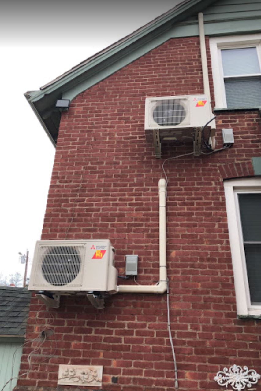 Heat pumps installed on the outside of a red, brick building in New York state. 