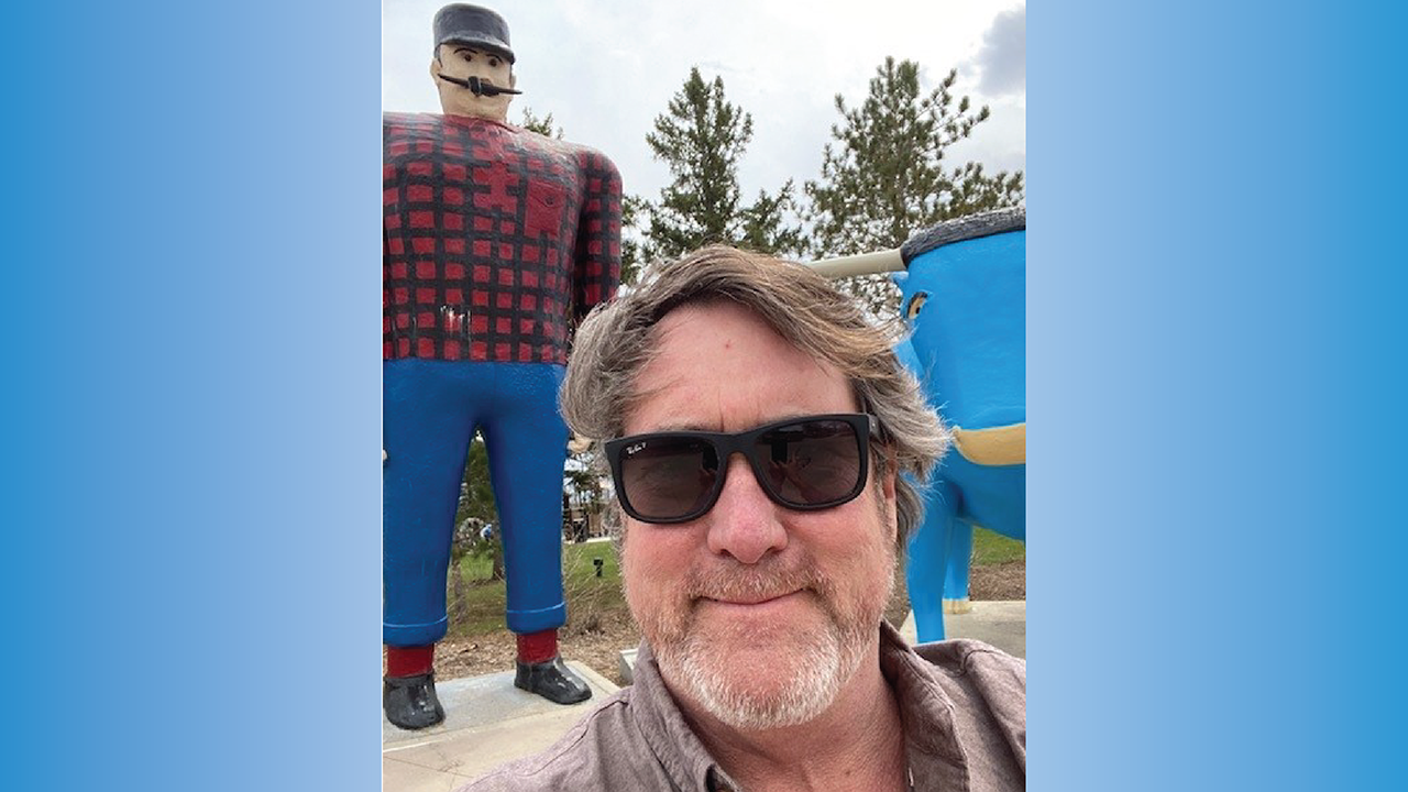 John in front of Paul Bunyan & Babe the Blue Ox Statues in Bemidji Minnesota.