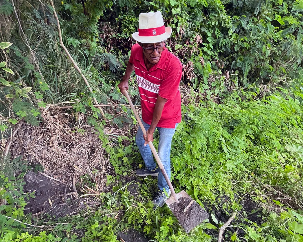 An activist from Guayama, Puerto Rico digs into the embankment next to a major road