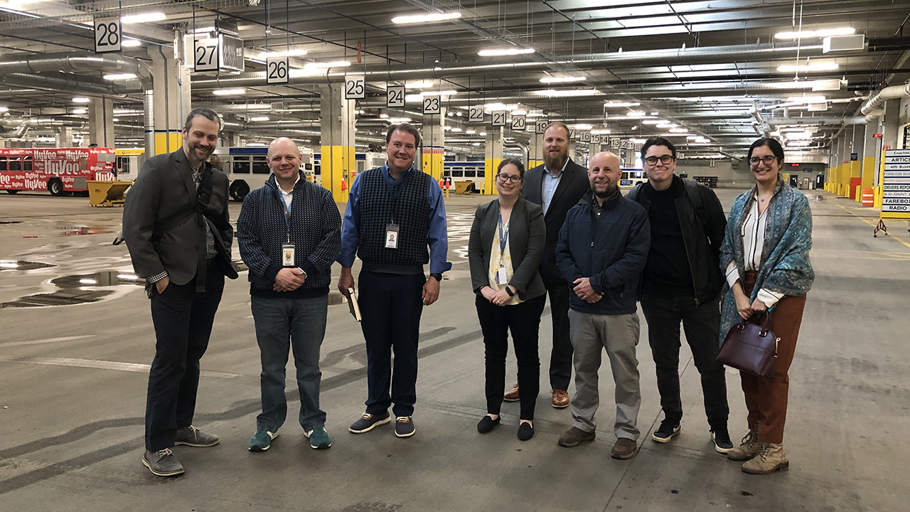 group of people smiling in Metro Transit's bus depot