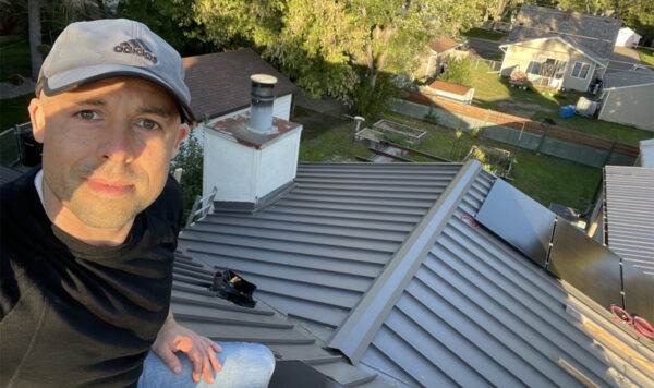 Eric Hammang poses on his roof while installing his solar panels.