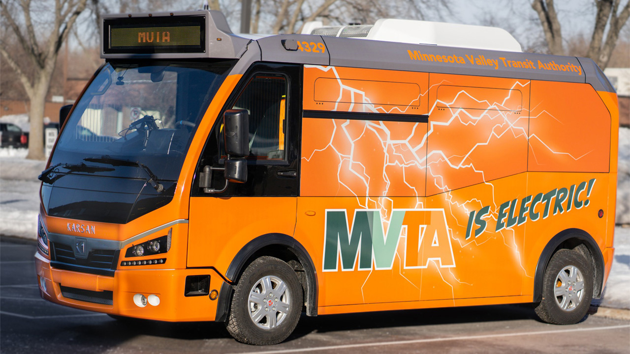 MVTA;s orange electric mini-bus parked in a parking lot.